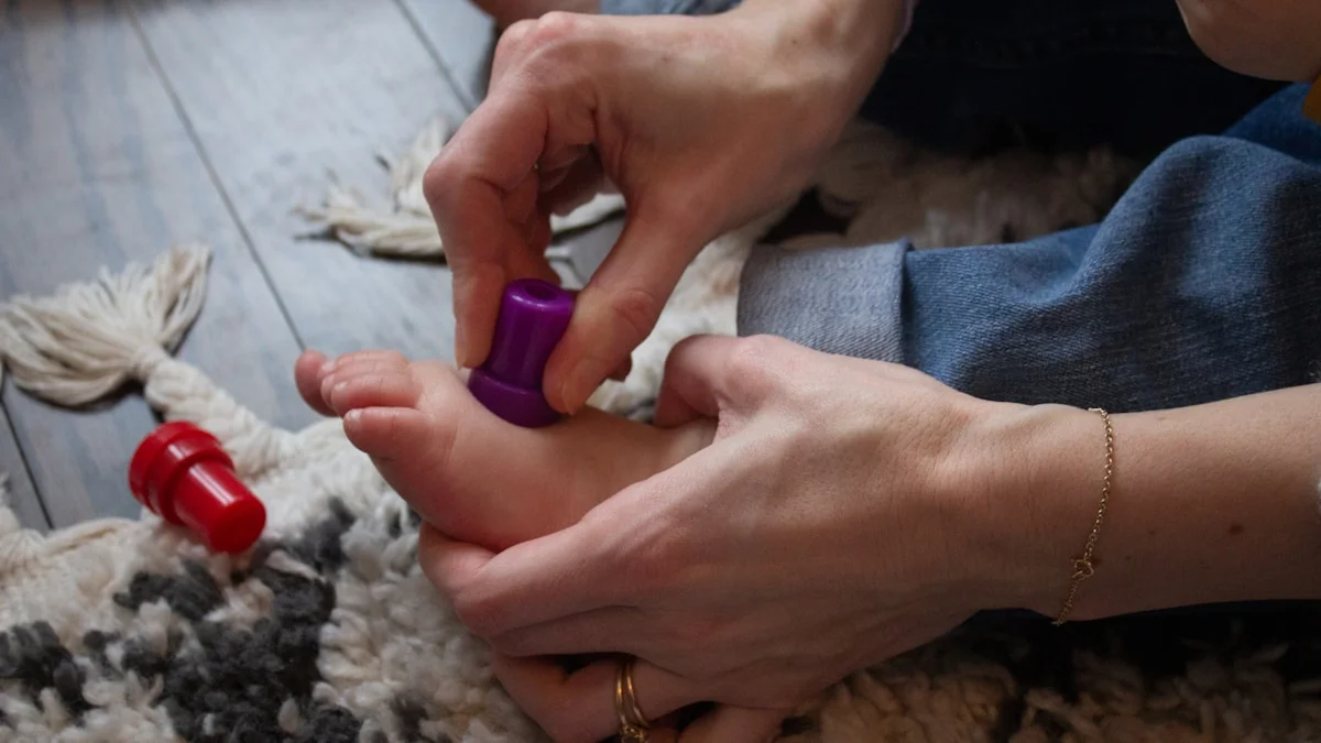 close-up of hands gently massaging and rotating a foot, warm backlighting, wellness and self-care concept