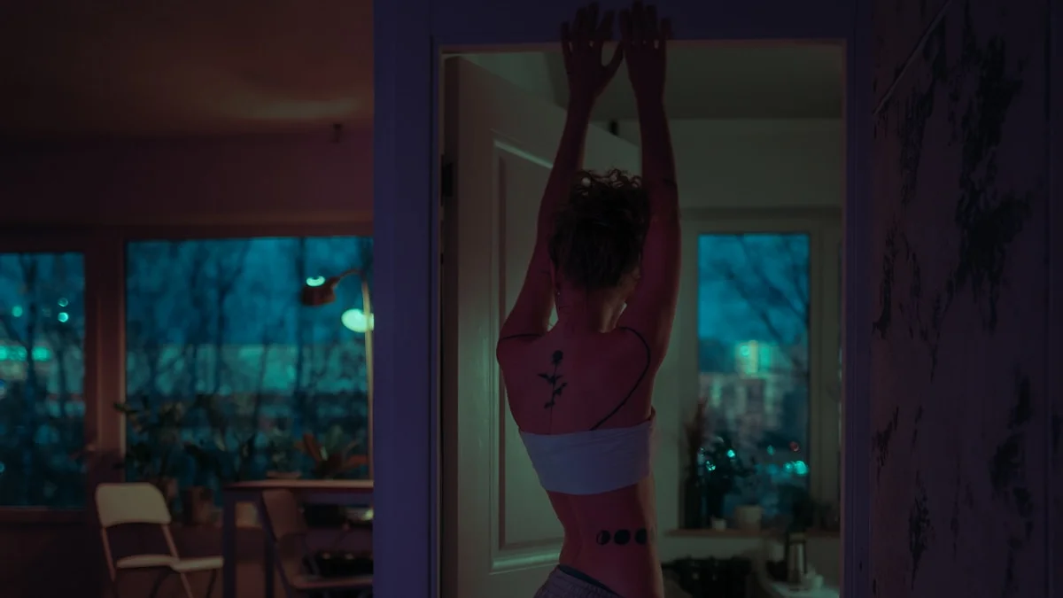 close-up of a warm towel gently placed on a person's abdomen, soft bedroom lighting, cozy atmosphere